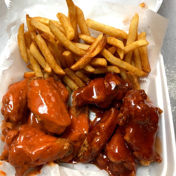 Hooks Fish & Chicken Plus's buffalo wings and french fries in a white styrofoam container.