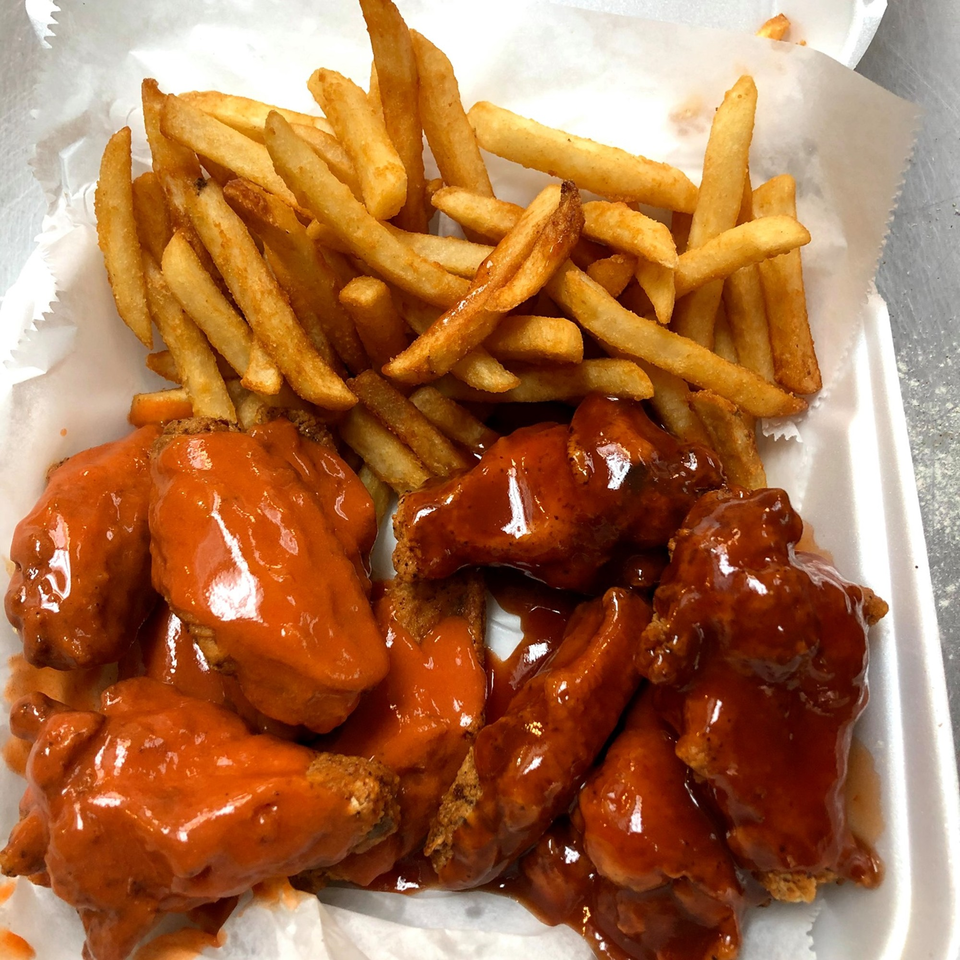 Hooks Fish & Chicken Plus's buffalo wings and french fries in a white styrofoam container.